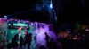 Migrantpolitan bei Nacht in Partystimmung mit Nebel und buntem Licht