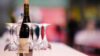 A bottle of wine is sitting on a table set with glasses
