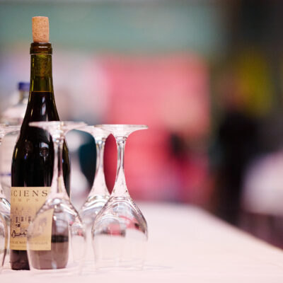 A bottle of wine is sitting on a table set with glasses