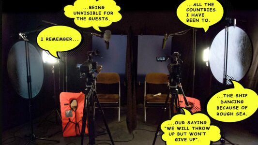 In einem kleinen Raum stehen zwei Stühle nebeneinander, drum herum sind Mikrofone und Kameras aufgebaut und zwei orangene Rettungswesten lehnen an den Stühlen. Auf dem Foto sind gelbe Sprechblasen im Comic-Stil eingebaut mit Gedankenfetzen.