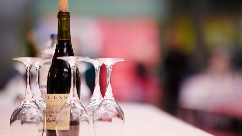 A bottle of wine is sitting on a table set with glasses