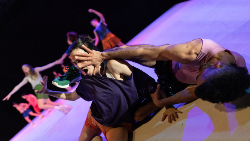 Two performers in Ayelen Parolin’s production “Irresistible Revolution” interact on stage. One person holds the  hand in front of the other’s face.