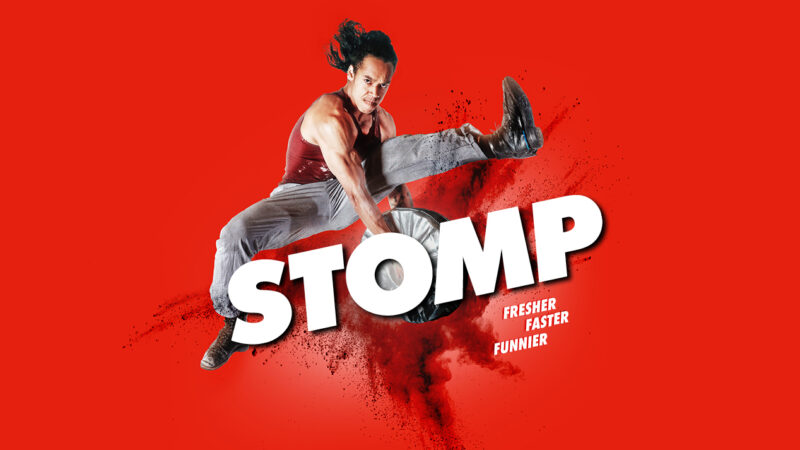 Stomp Titelmotiv. Eine tanzende Person springt mit gestreckten Beinen in die Luft und schlägt zwei Platten gegeneinander. Unter ihr steht »Stomp« in Großbuchstaben und mit dem Untertitel "Fresher, Faster, Funnier".